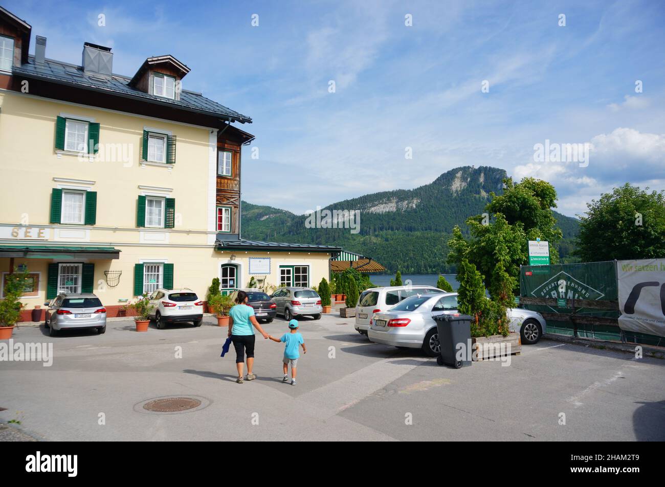 AULTAUSSEE, AUSTRIA - Nov 07, 2021: The woman and child walking close by a hotel and lake. Aultaussee, Austria Stock Photo