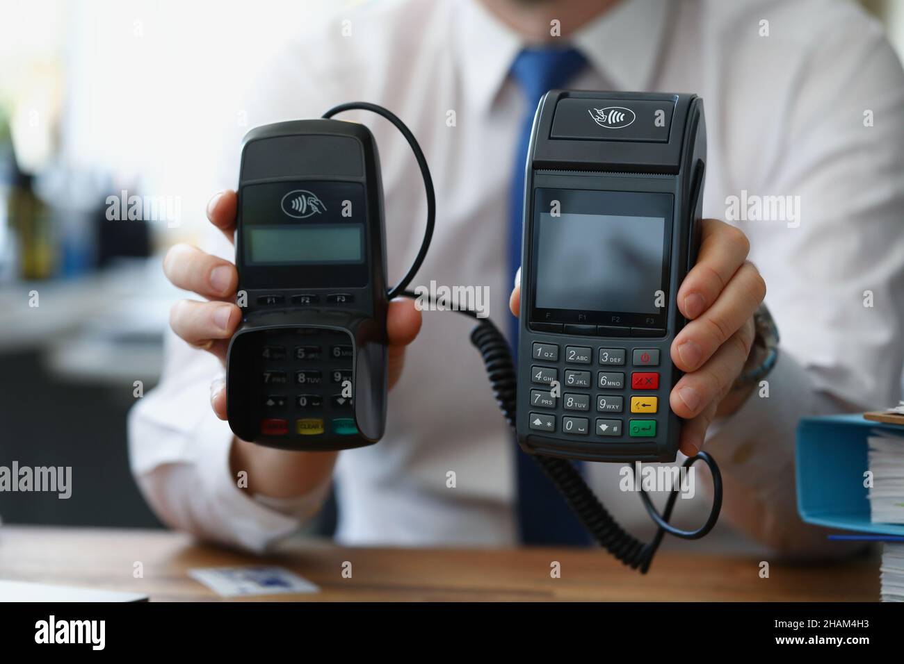 Man hold different models of credit card reader machines for cashless