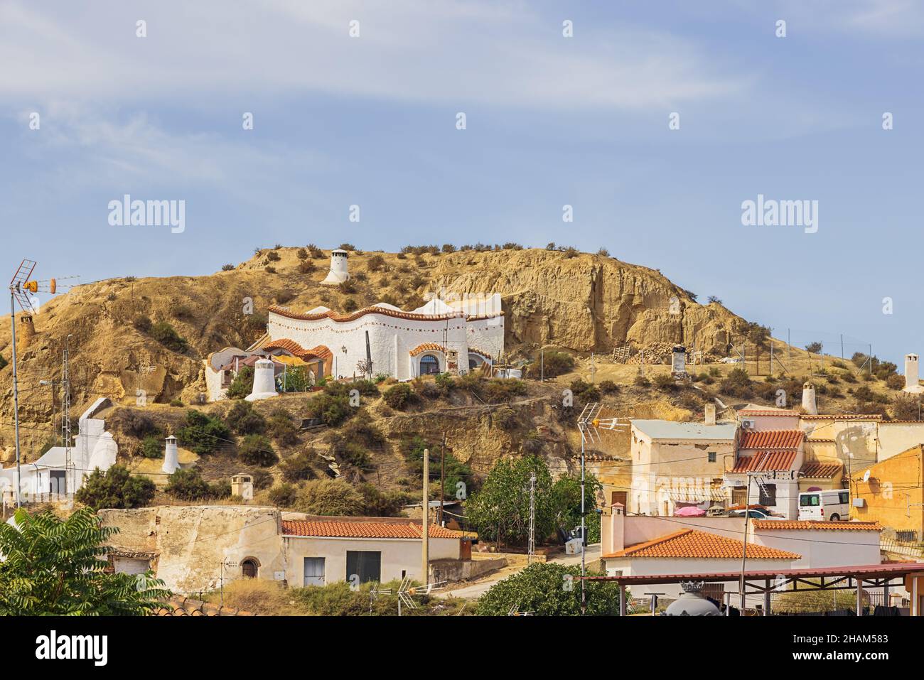 Troglodyte habitations against a hill in Guadix Stock Photo