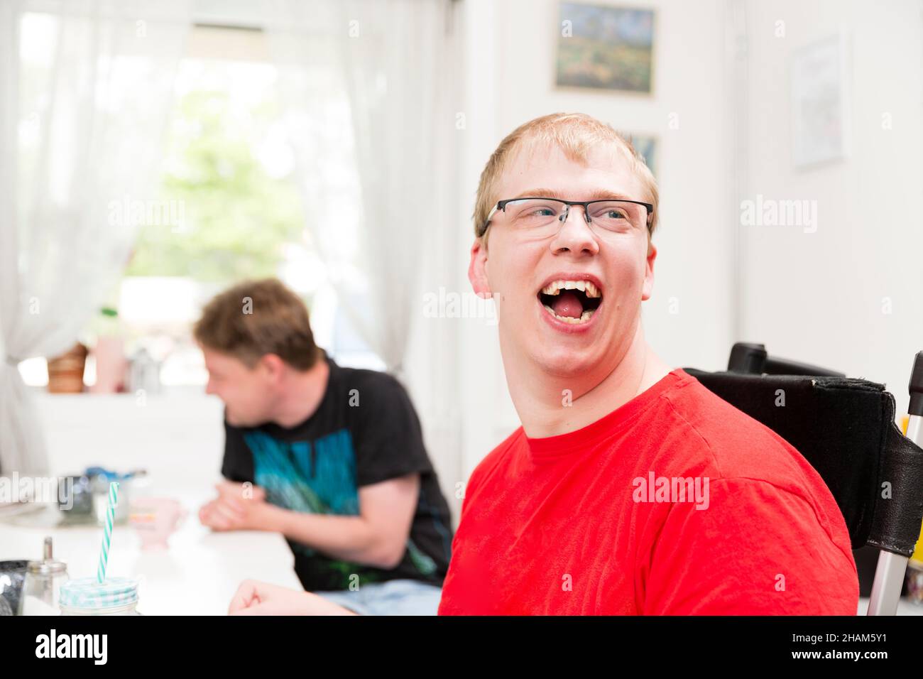 Smiling young disabled man in eyeglasses Stock Photo