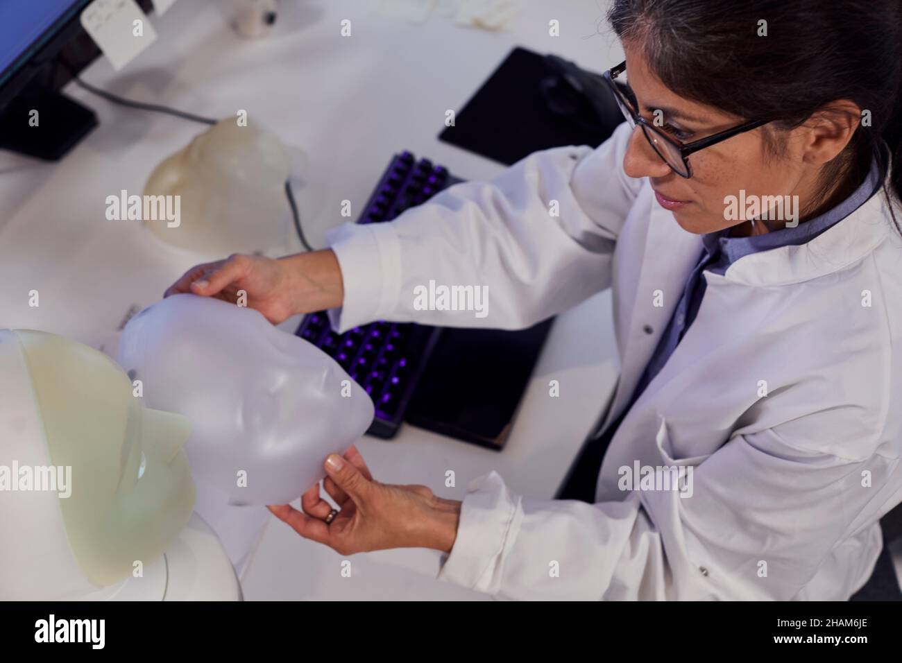 Female engineer building robot with human face Stock Photo