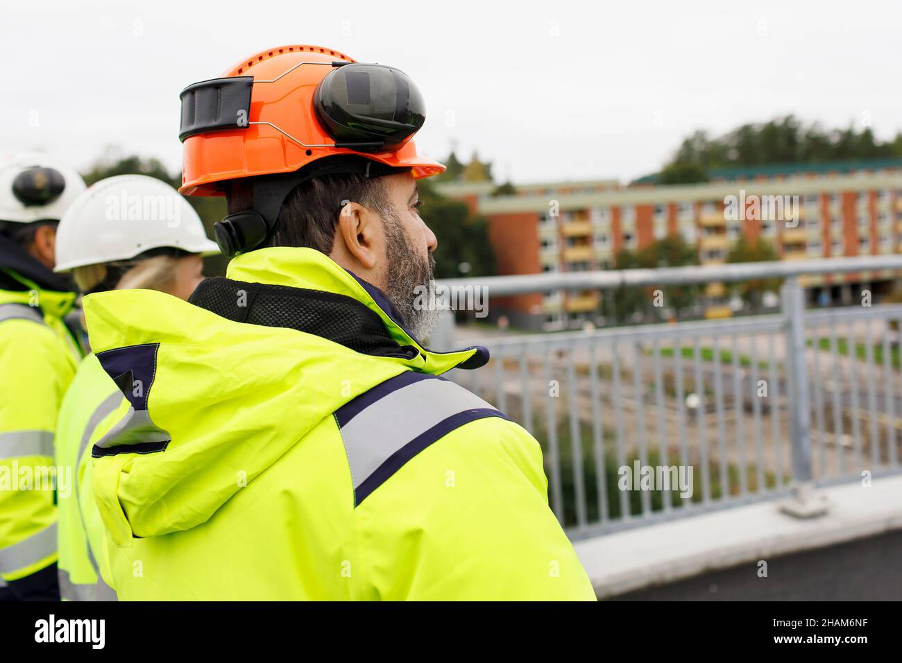 Engineers in reflective clothing walking on bridge Stock Photo