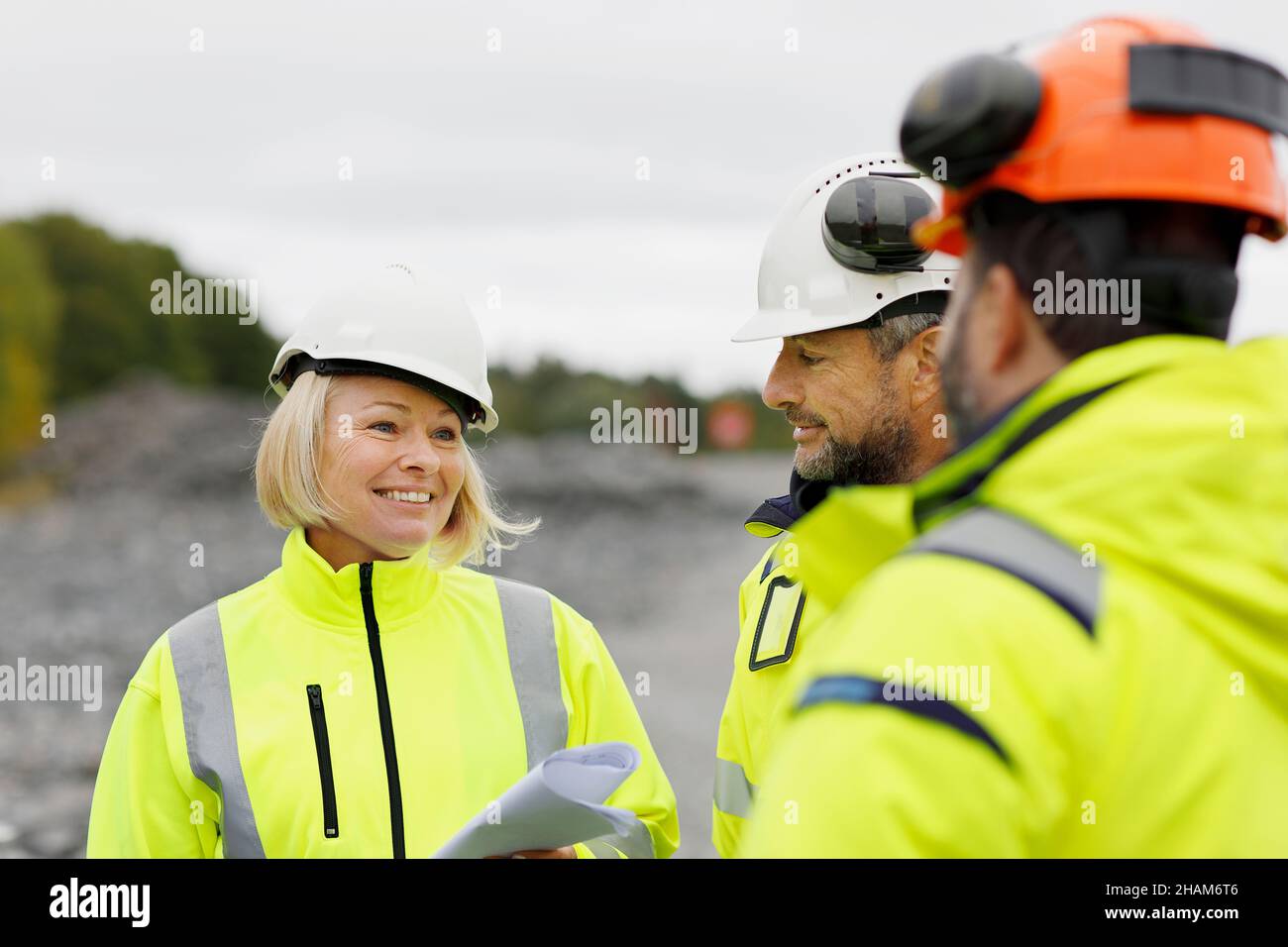 Engineers in reflective clothing discussing plans Stock Photo