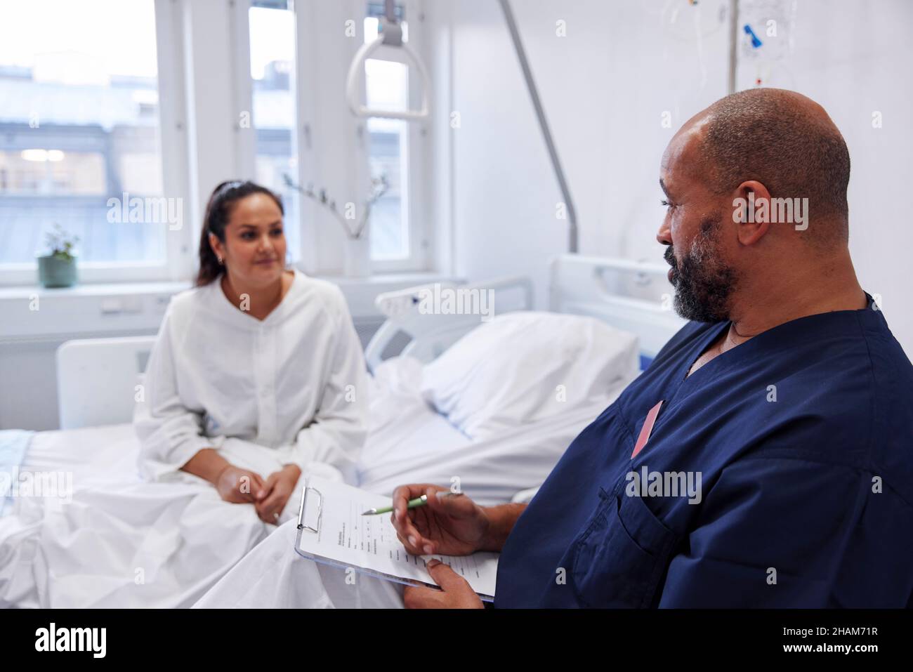 Female patient on hospital bed talking to nurse Stock Photo - Alamy