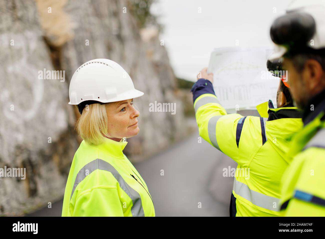 Engineers in reflective clothing discussing plans Stock Photo