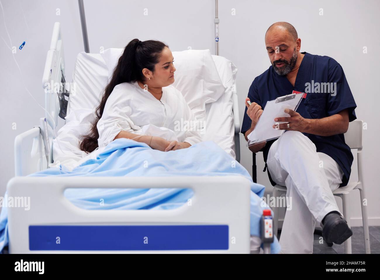 Female patient on hospital bed talking to nurse Stock Photo - Alamy