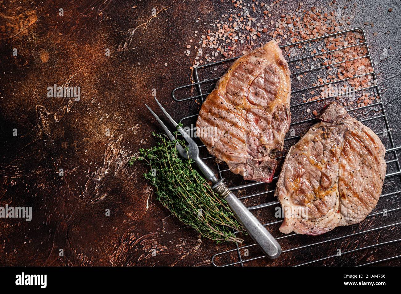 BBQ Grilled Pork loin steaks from neck fillet meat on grill. Dark