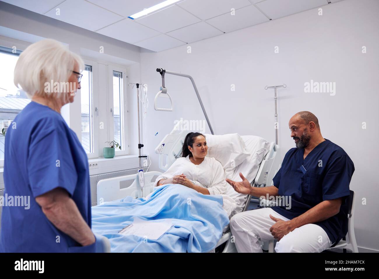 Female patient on hospital bed talking to nurse Stock Photo - Alamy