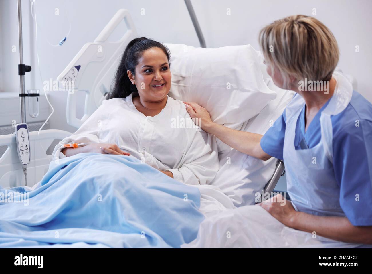 Female patient on hospital bed talking to nurse Stock Photo - Alamy