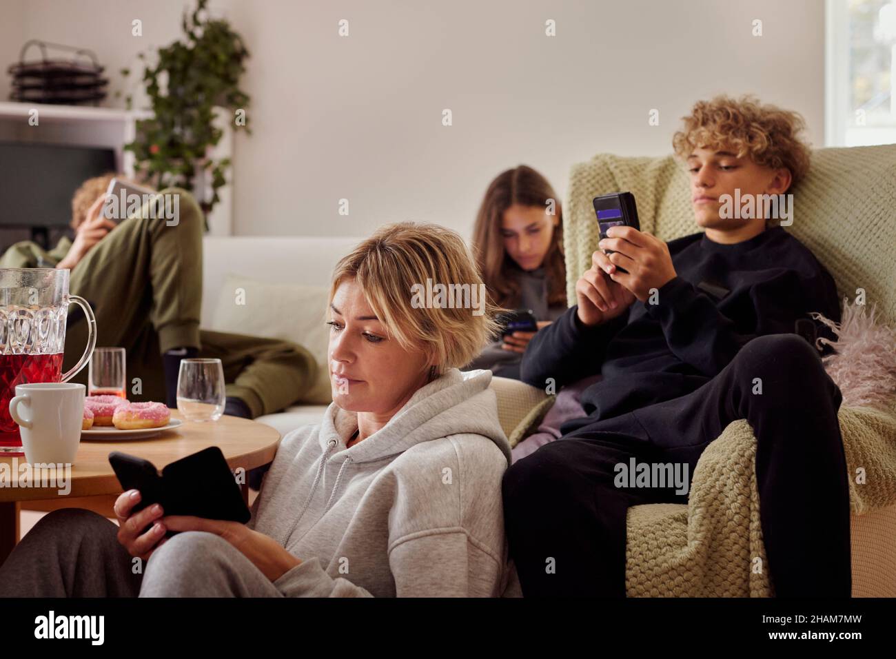 Family using smart phones in living room Stock Photo Alamy