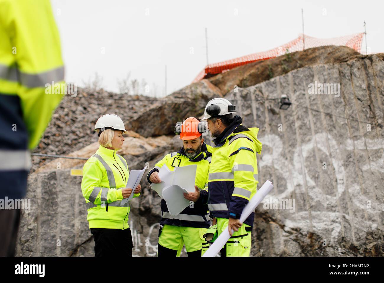 Engineers in reflective clothing discussing plans Stock Photo