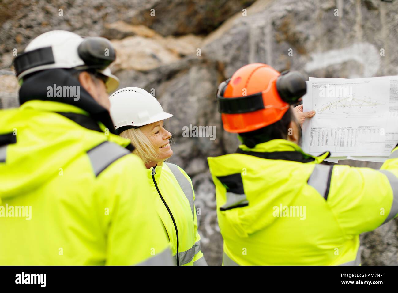 Engineers in reflective clothing discussing plans Stock Photo