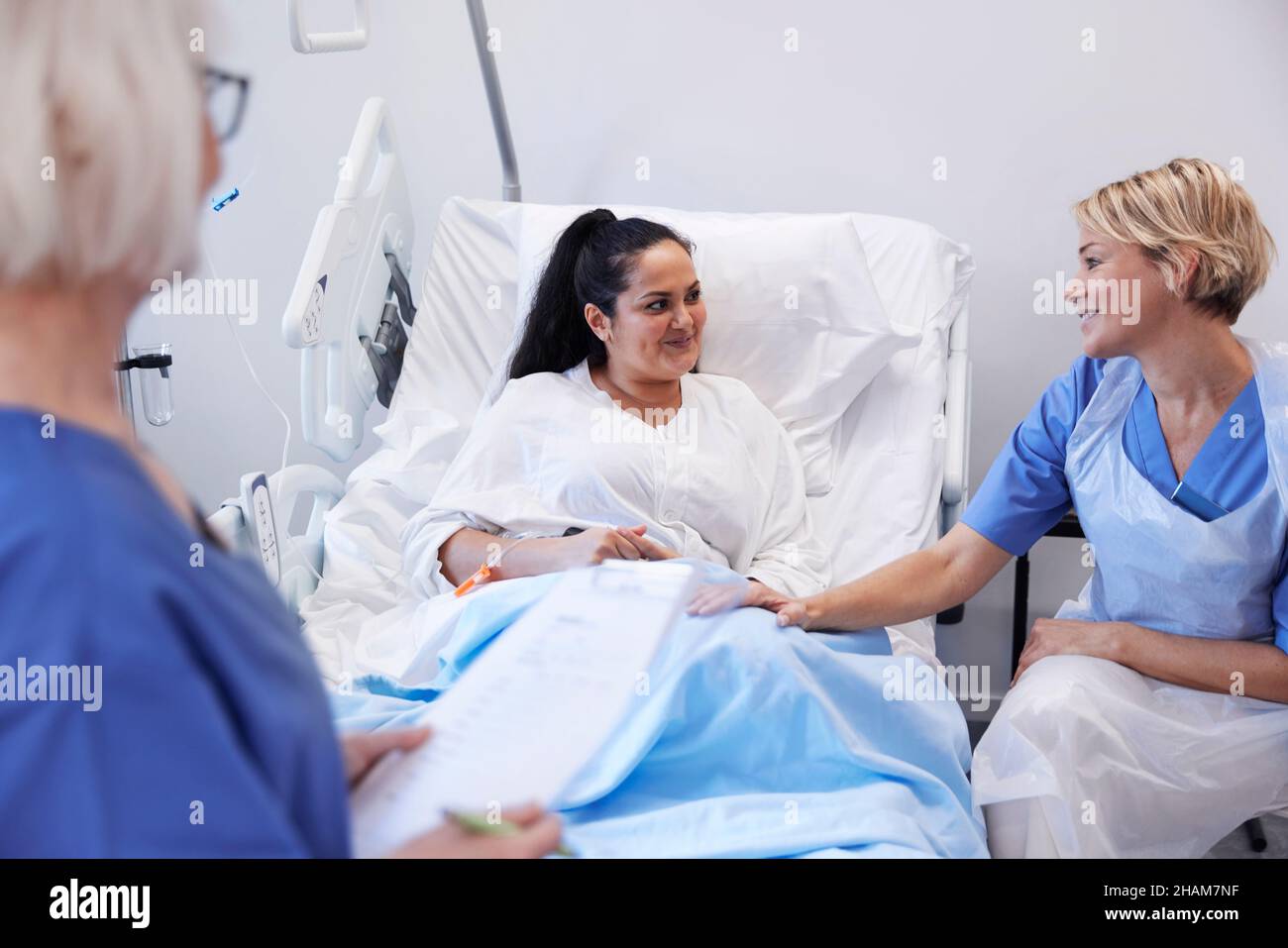 Female patient on hospital bed talking to nurse Stock Photo - Alamy