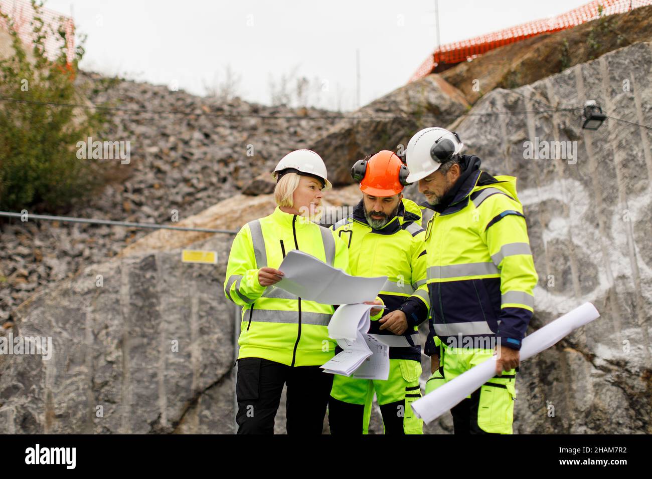 Engineers in reflective clothing discussing plans Stock Photo