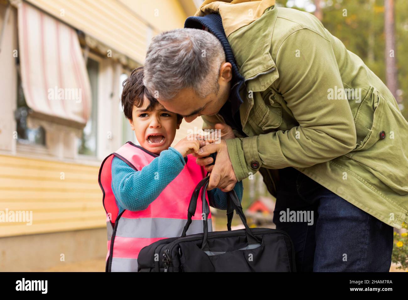 Father collecting crying son from school Stock Photo