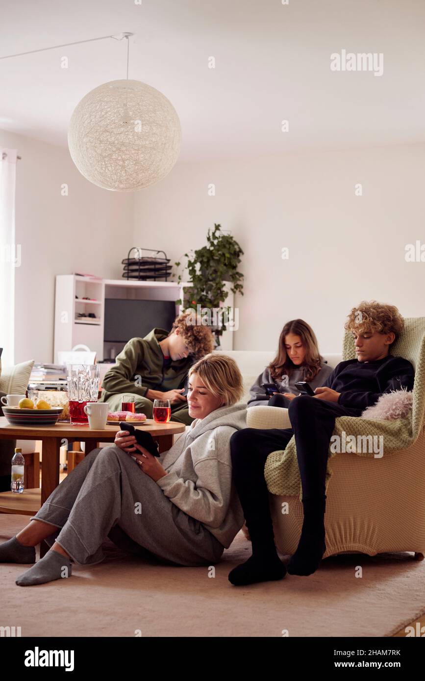 Family using smart phones in living room Stock Photo