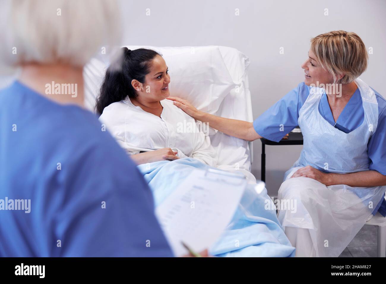 Female patient on hospital bed talking to nurse Stock Photo - Alamy