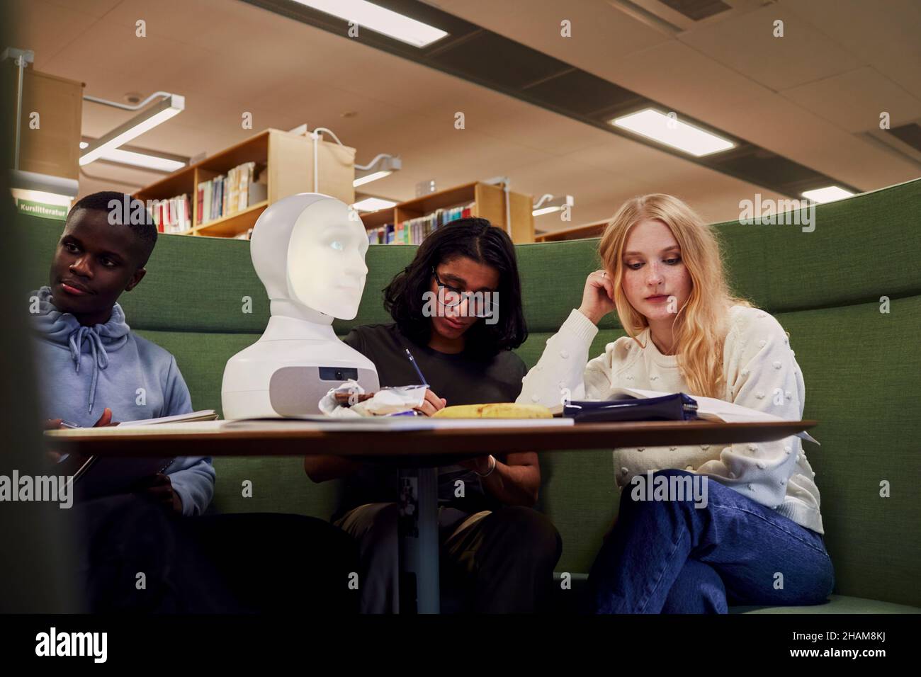 Friends sitting together in library Stock Photo