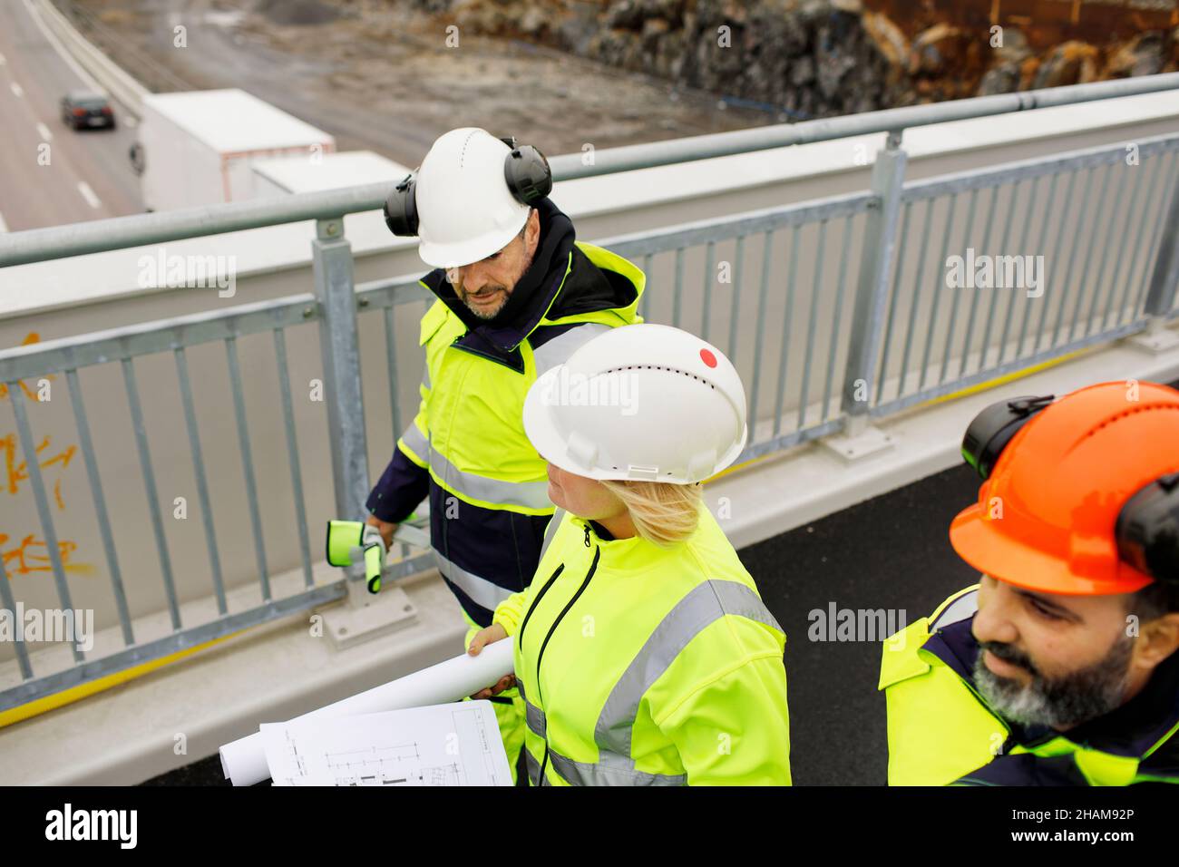 Engineers in reflective clothing walking on viaduct Stock Photo
