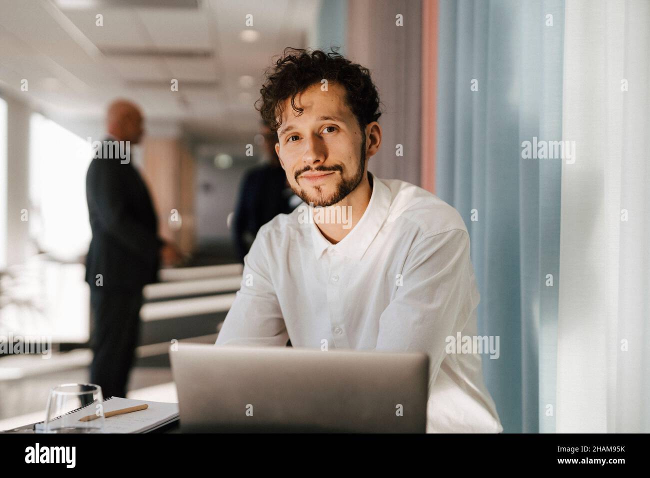 Man with laptop sitting in office Stock Photo