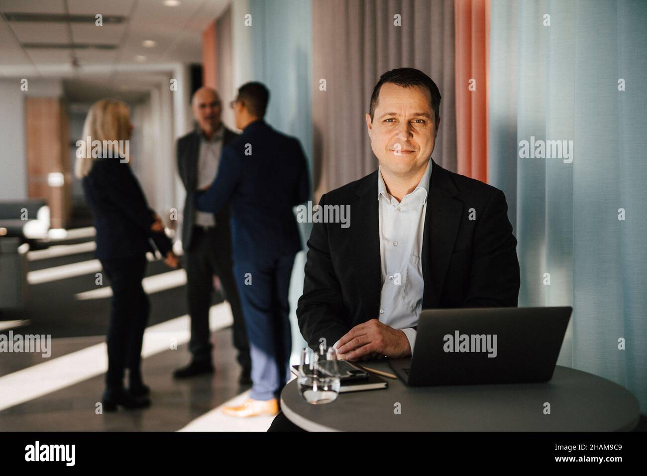 Man with laptop sitting in office Stock Photo
