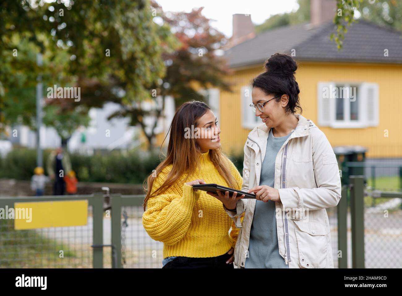 Smiling women using digital tablet outside Stock Photo