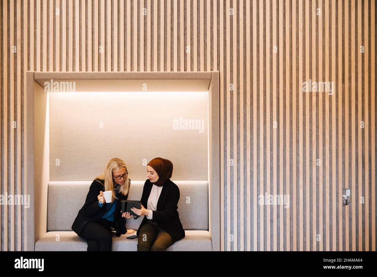 Female coworkers talking together Stock Photo