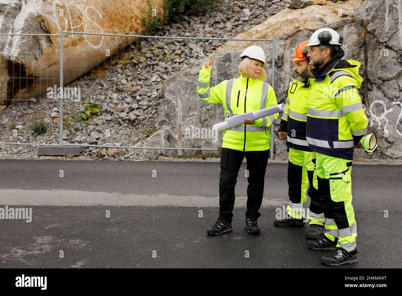 Engineers in reflective clothing discussing plans Stock Photo