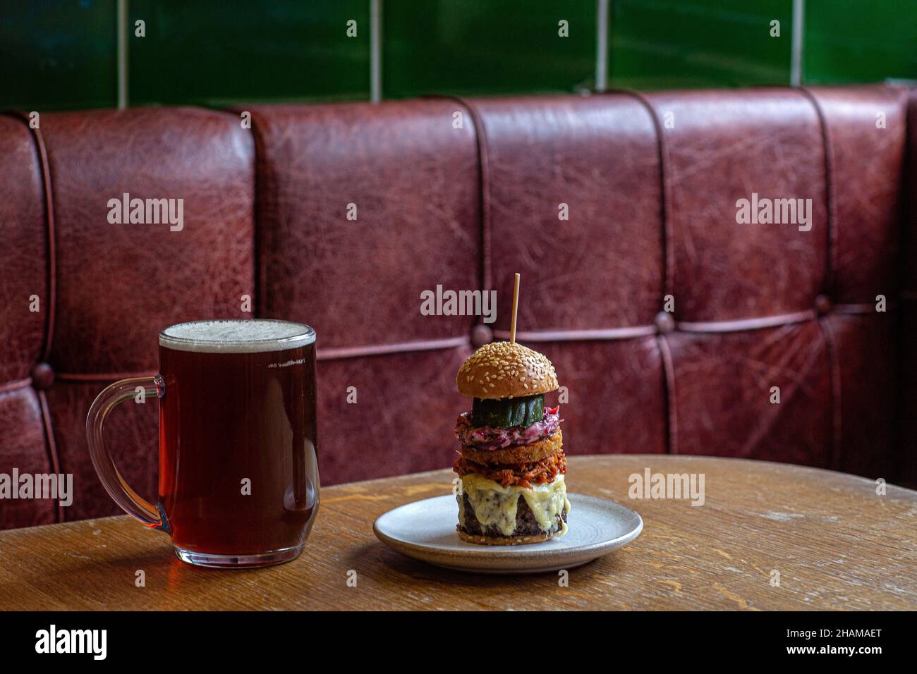 The Coach Burger with Cheddar, Pulled Pork and Dill Pickle at The Coach in Marlow, Buckinghamshire, UK indoor Stock Photo