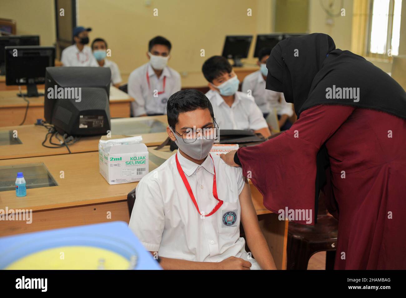 Non Exclusive: SYLHET, BANGLADESH - DECEMBER 13, 2021: A student of Pilot High School receives a dose of COVID-19 vaccine during the vaccination campa Stock Photo