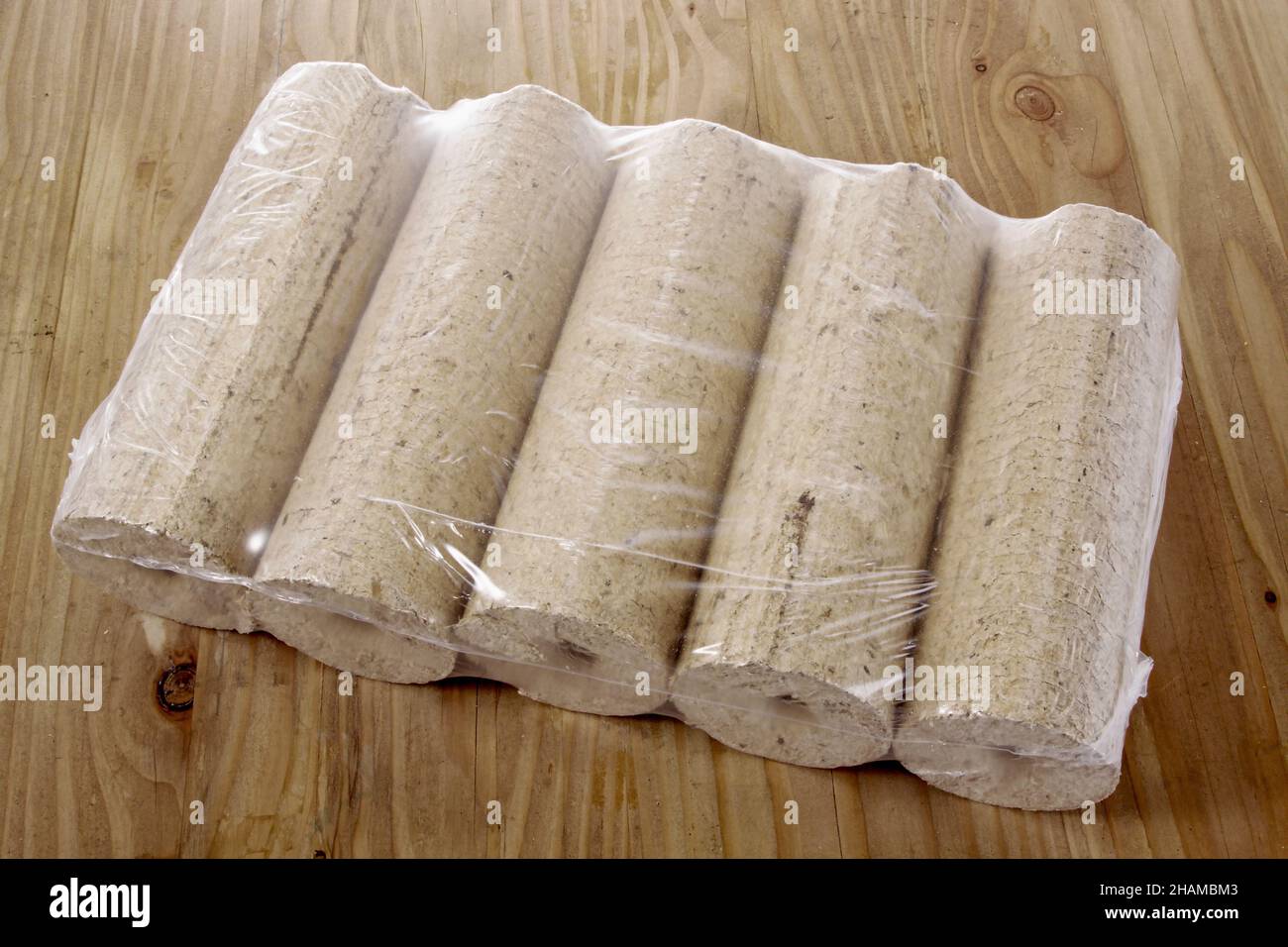 round wooden briquettes on wooden table Stock Photo