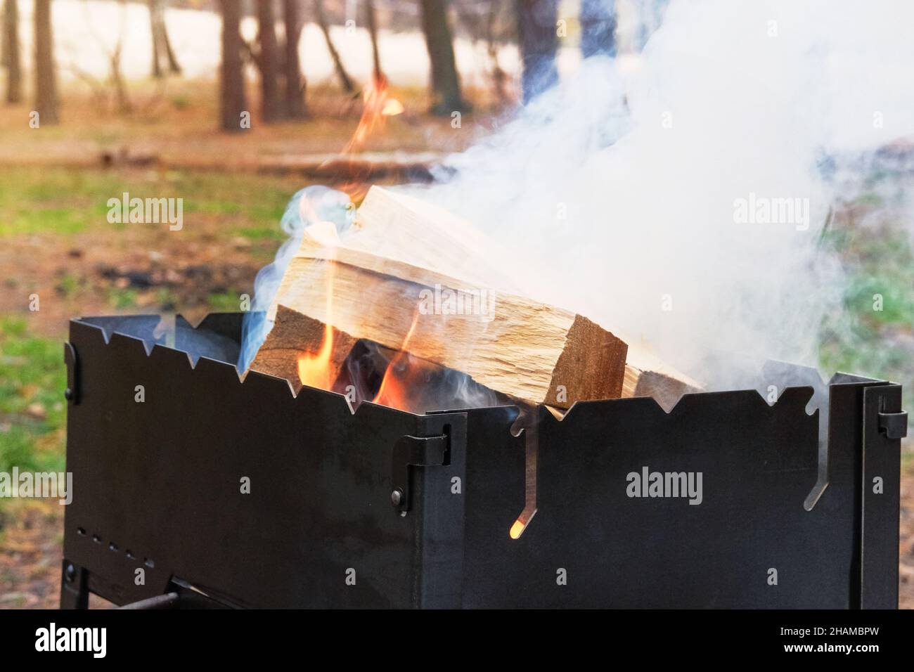 Grill with burning firewood and smoke. Wood fire prepared for barbecue