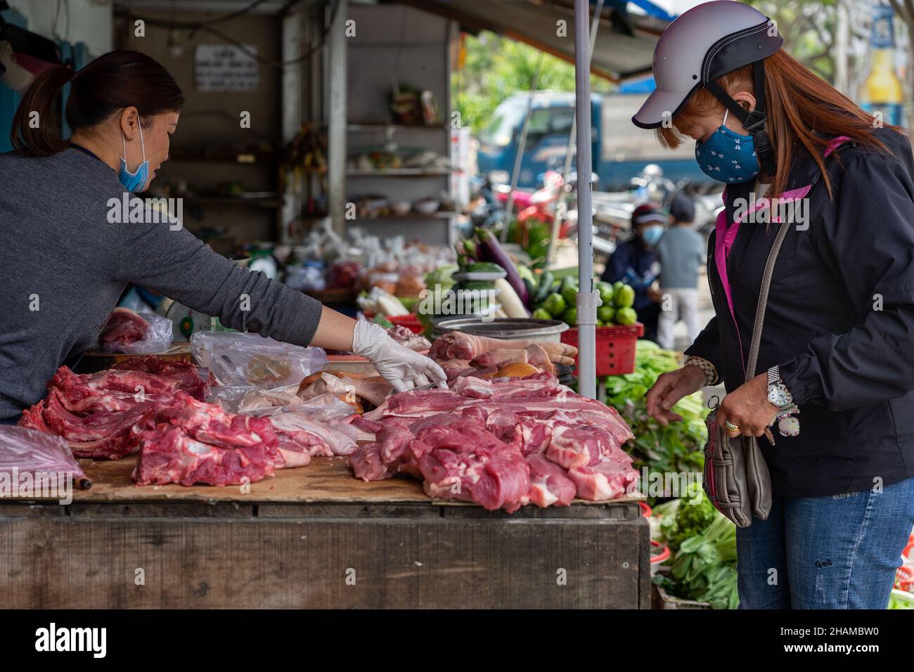 Meat stall in the street market. Woman buys pork. Da Lat, Vietnam: 2021-05-08 Stock Photo