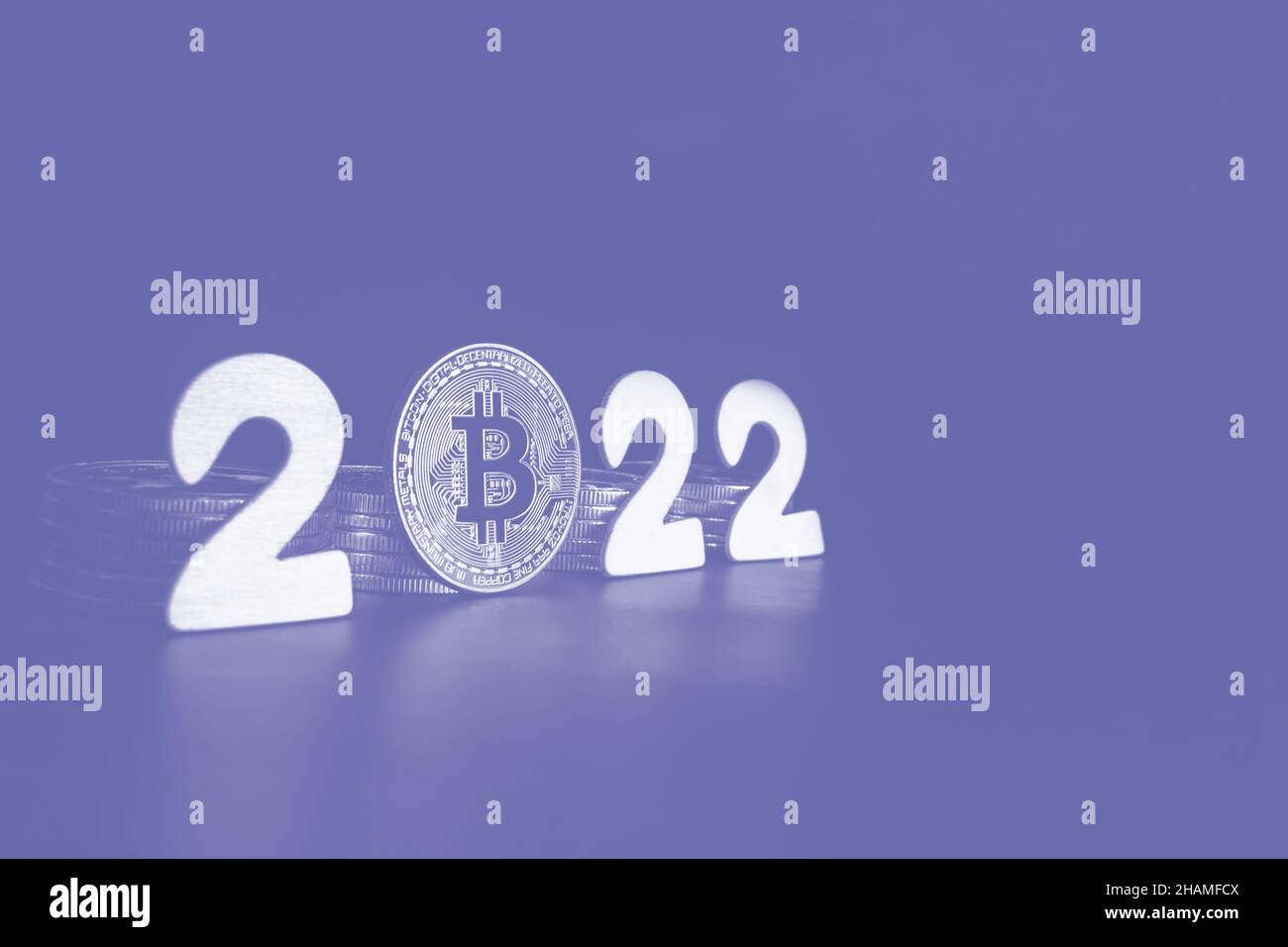 Bitcoin 2022 sign. Single Bitcoin coin next to the numbers with copy space for text toned in very peri color of the year. Price, future value of BTC crypto prediction concept. Stock Photo