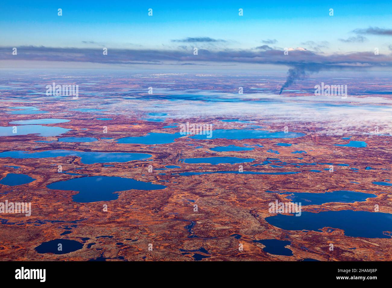 Aerial view of the tundra in autumn. Oilfield in marsh terrain under cloudy sky. Extensive gas producing province in Western Siberia, Russia. Stock Photo