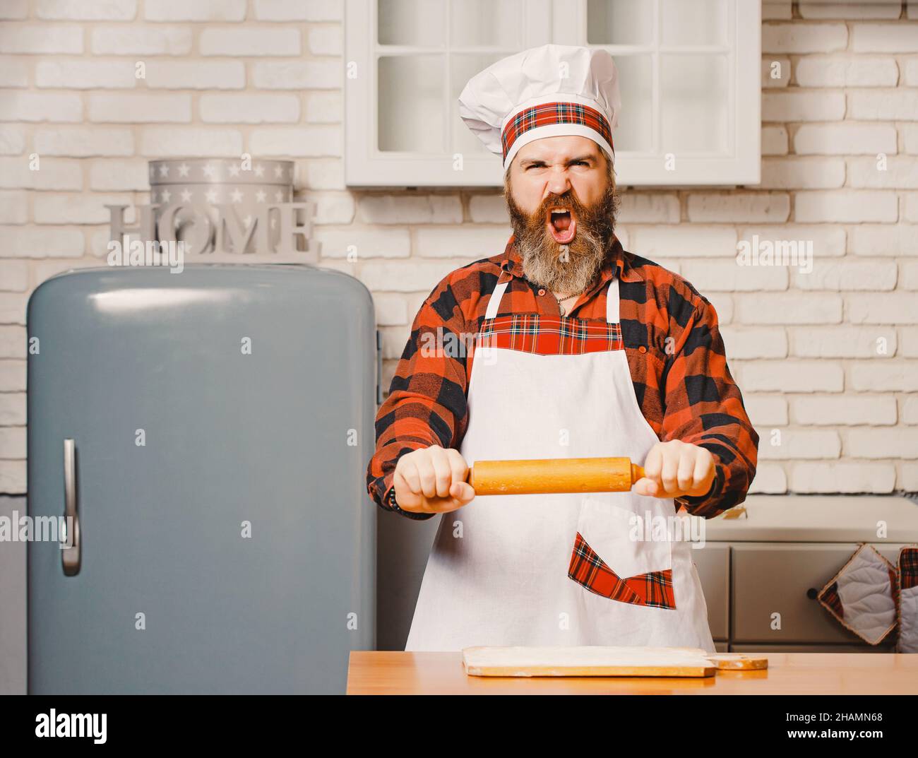 Angry chef bakers man raising rolling pin threateningly in white ...