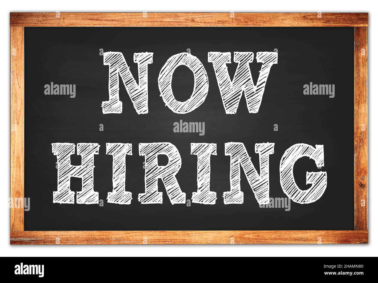 NOW HIRING written on black wooden frame school blackboard Stock Photo
