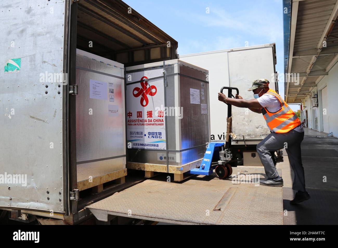 Maputo, Mozambique. 12th Dec, 2021. A staff member transfers the new batch of COVID-19 Sinopharm vaccines donated by China at the Maputo International Airport in Maputo, Mozambique, Dec. 12, 2021. Another batch of COVID-19 Sinopharm vaccines donated by China has arrived in Mozambique to help the African country better deal with the pandemic. Credit: Nie Zuguo/Xinhua/Alamy Live News Stock Photo