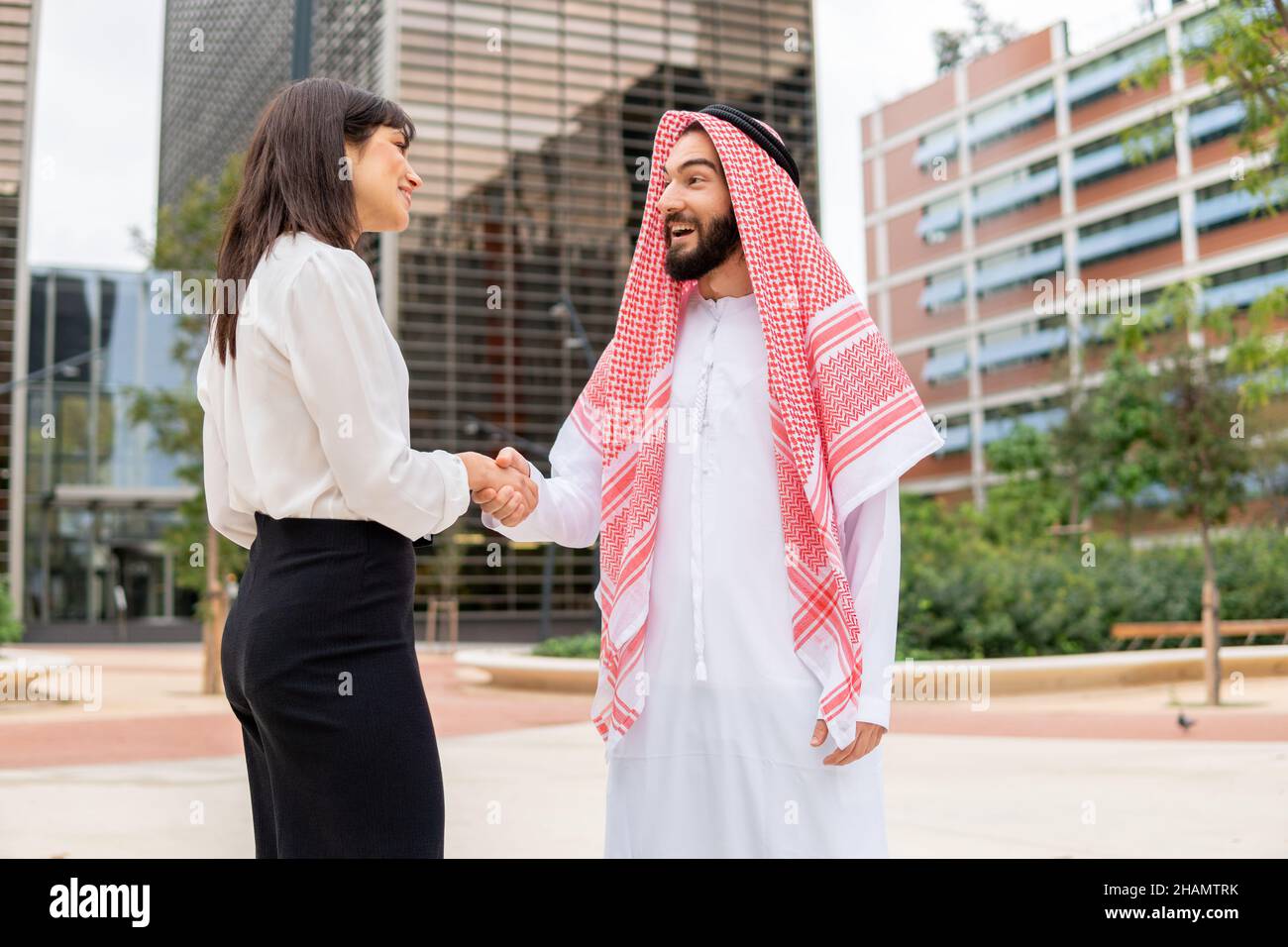 Handshake of arab sheikh man and european business woman, diverse