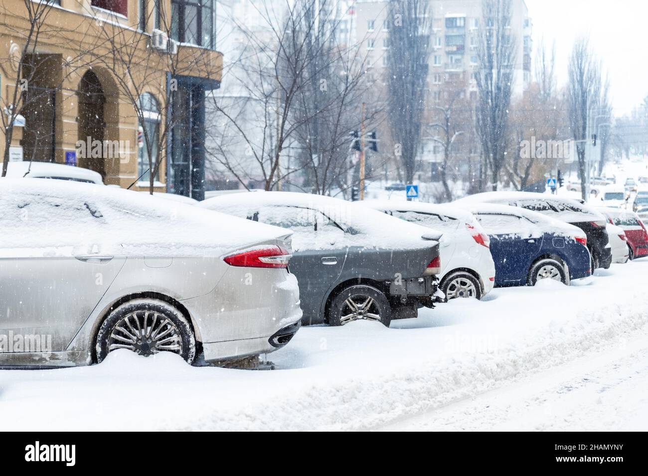 City street driveway parking lot with many cars covered by snow stucked ...