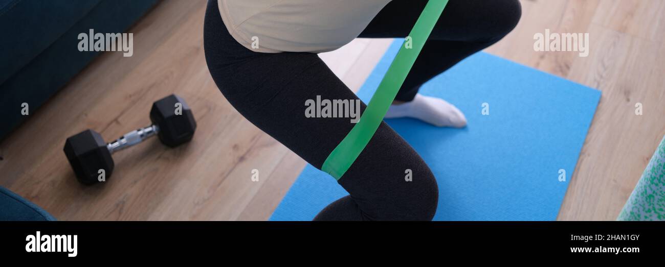 Woman doing squats with rubber band at home Stock Photo Alamy