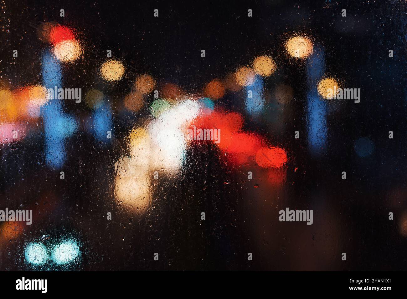 Car traffic from behing a wet window at night Stock Photo