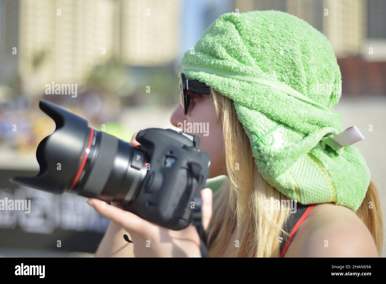 Young woman photographer taking photos outdoor on digital camera at a daytime Stock Photo