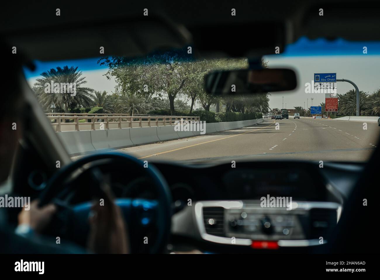 Driving a Car on the Abu Dhabi Road Highway with Dashboard Speedometer in Front of the Steering Wheel Stock Photo