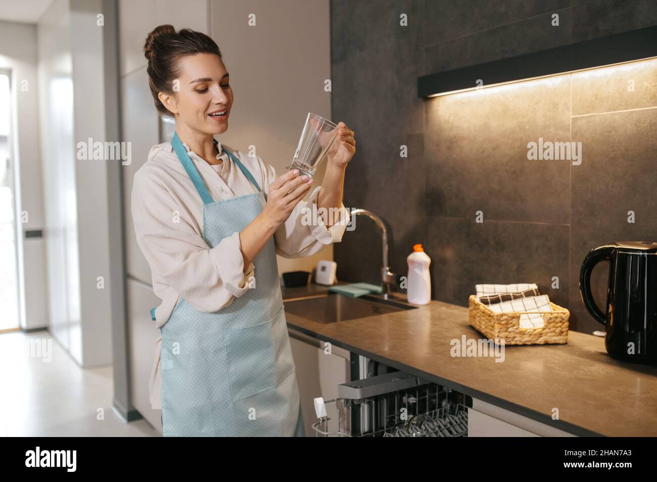 Woman holding glasses washed glaases and scrutinizing them Stock Photo