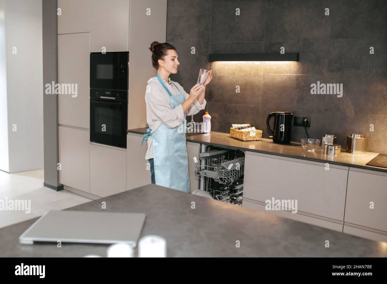 Woman holding glasses washed glaases and scrutinizing them Stock Photo