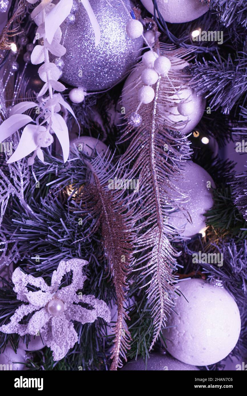 Numerous decorative tinsels on Christmas tree in violet tone. Color of 2022. Very Peri pantone Stock Photo