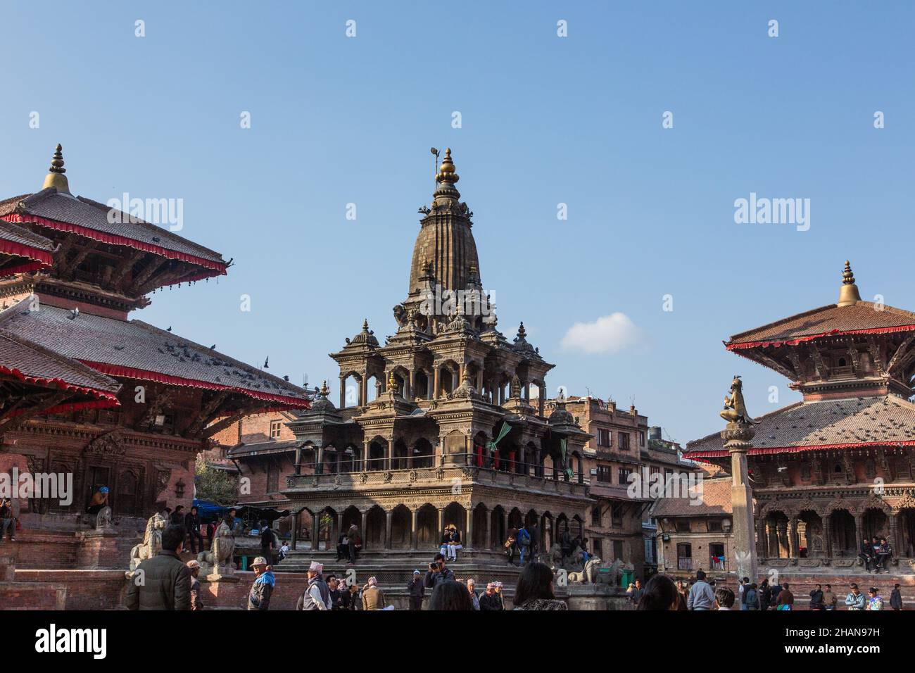 The Krishna Mandir Temple, a sikhara-style Hindu temple in Durbar Square, Patan, Nepal. At right, are the Garuda statue and the Vishwanath Temple. Stock Photo
