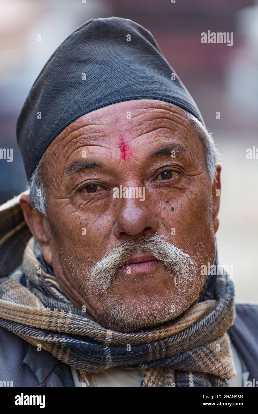 A Nepali man in a dhaka topi hat in the medieval Newari village of Khokana in the Kathmandu Valley of Nepal. Stock Photo