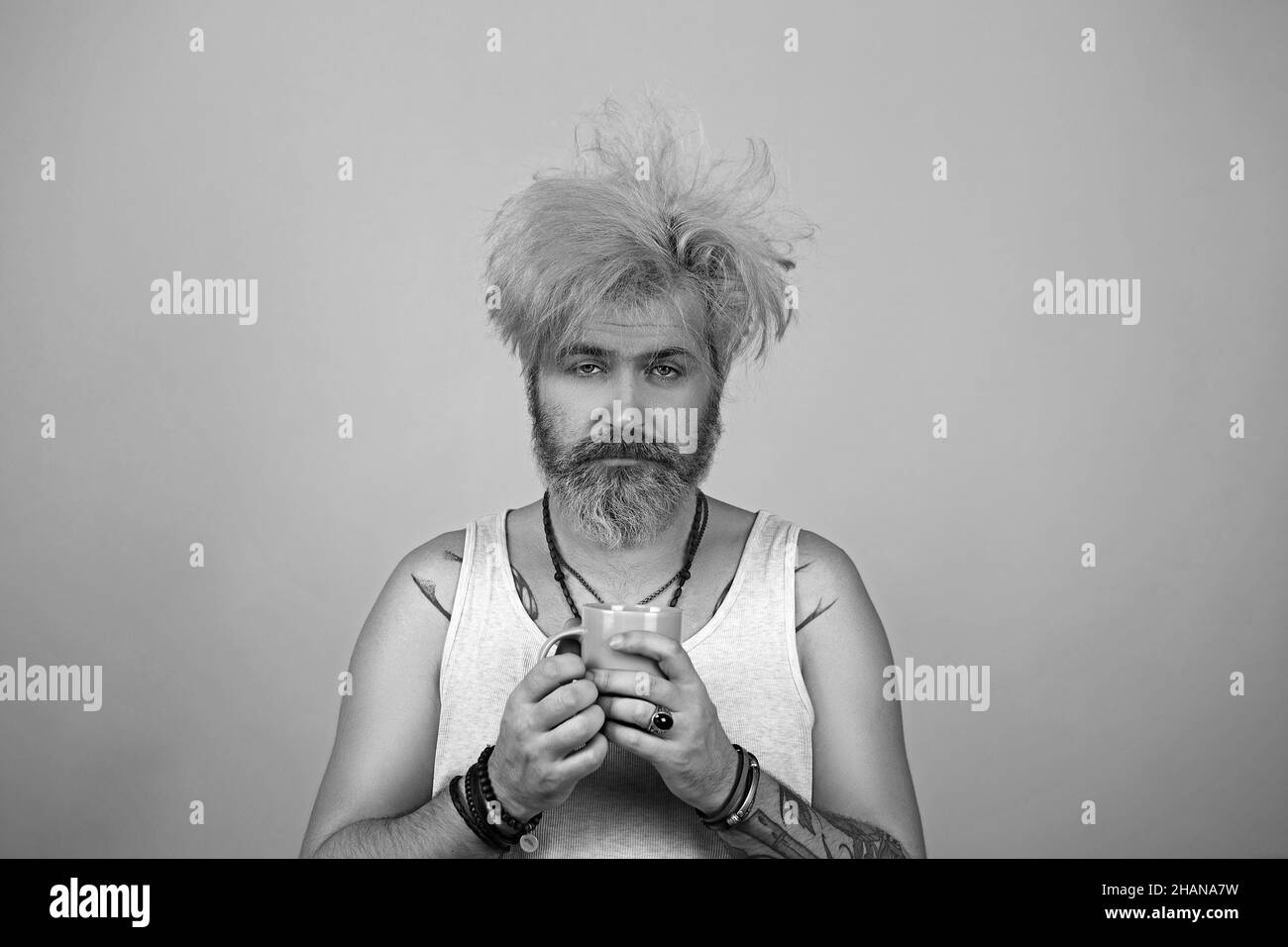 Concept of having headache after global party. In the morning sleepy man with coffee. Stock Photo